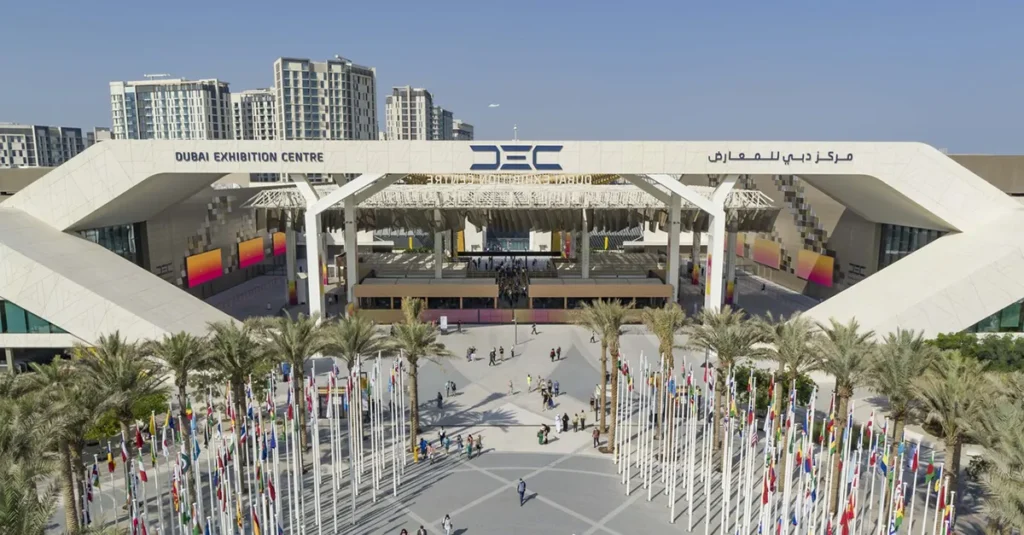 Dubai Exhibition Centre entrance at Expo City Dubai with international flags and event venue architecture.