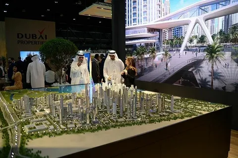 Investors and developers discussing a Dubai city development model at a real estate exhibition booth.
