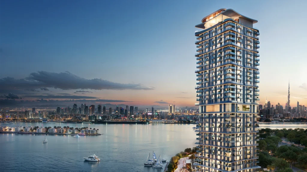 Luxury waterfront residential tower overlooking Dubai skyline and marina at sunset.